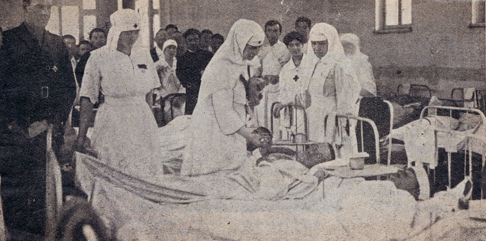 Regina Maria in uniforma de infirmiera alinand suferinta soldatilor